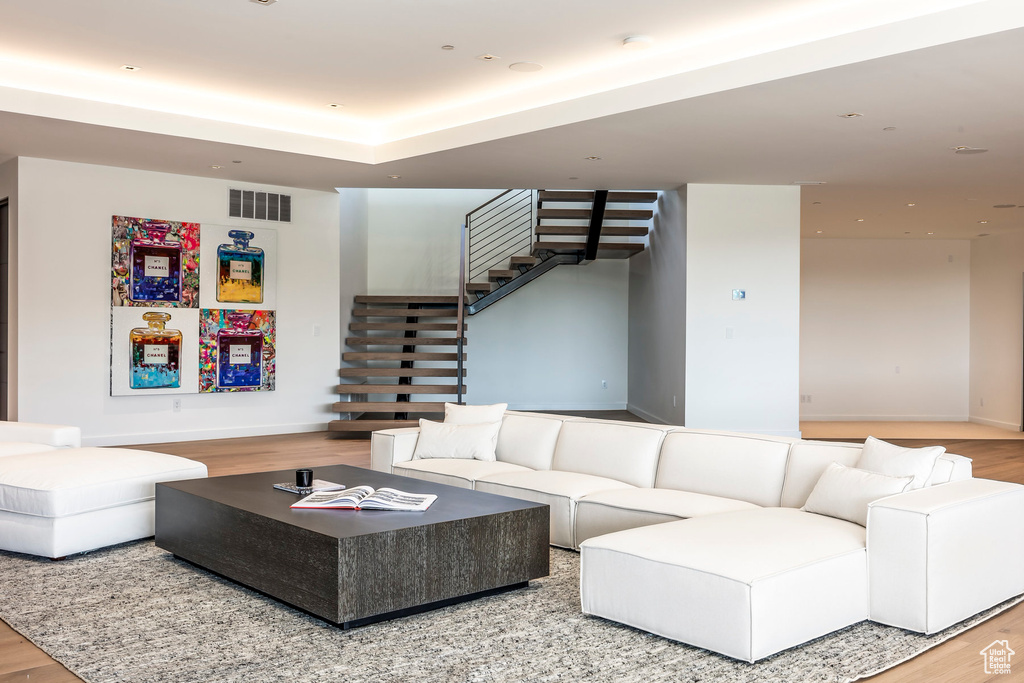Living area with wood finished floors, stairway, and baseboards
