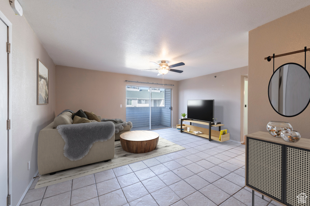 Tiled living room featuring ceiling fan and a textured ceiling