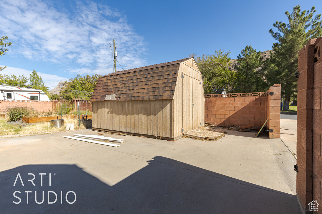 View of patio with a shed