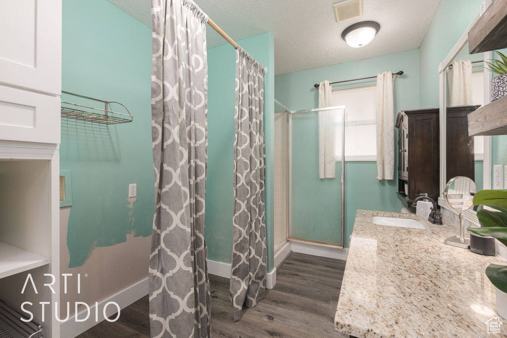 Bathroom with curtained shower, wood-type flooring, and vanity