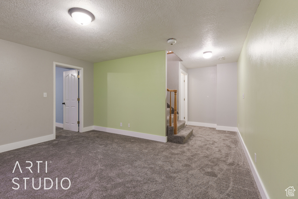 Unfurnished room featuring carpet and a textured ceiling