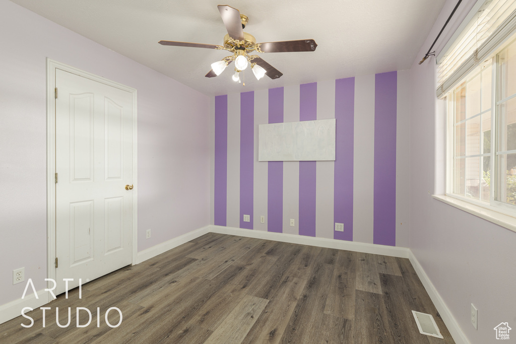 Spare room featuring dark hardwood / wood-style flooring and ceiling fan