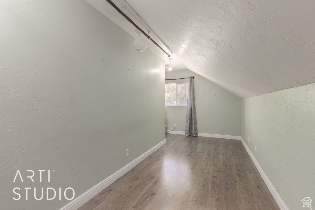 Bonus room with hardwood / wood-style floors and lofted ceiling