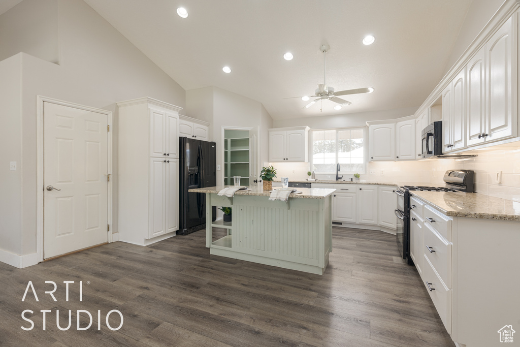 Kitchen with black refrigerator with ice dispenser, dark hardwood / wood-style floors, stainless steel range oven, and a center island