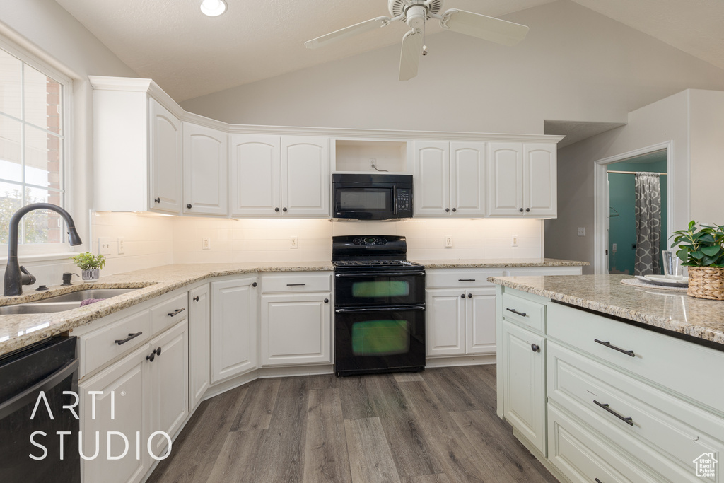 Kitchen featuring white cabinets, black appliances, and lofted ceiling