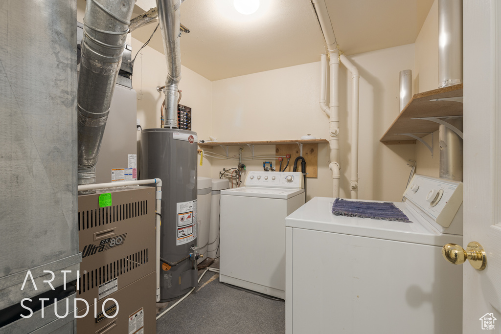 Clothes washing area featuring washer and dryer, water heater, and carpet floors