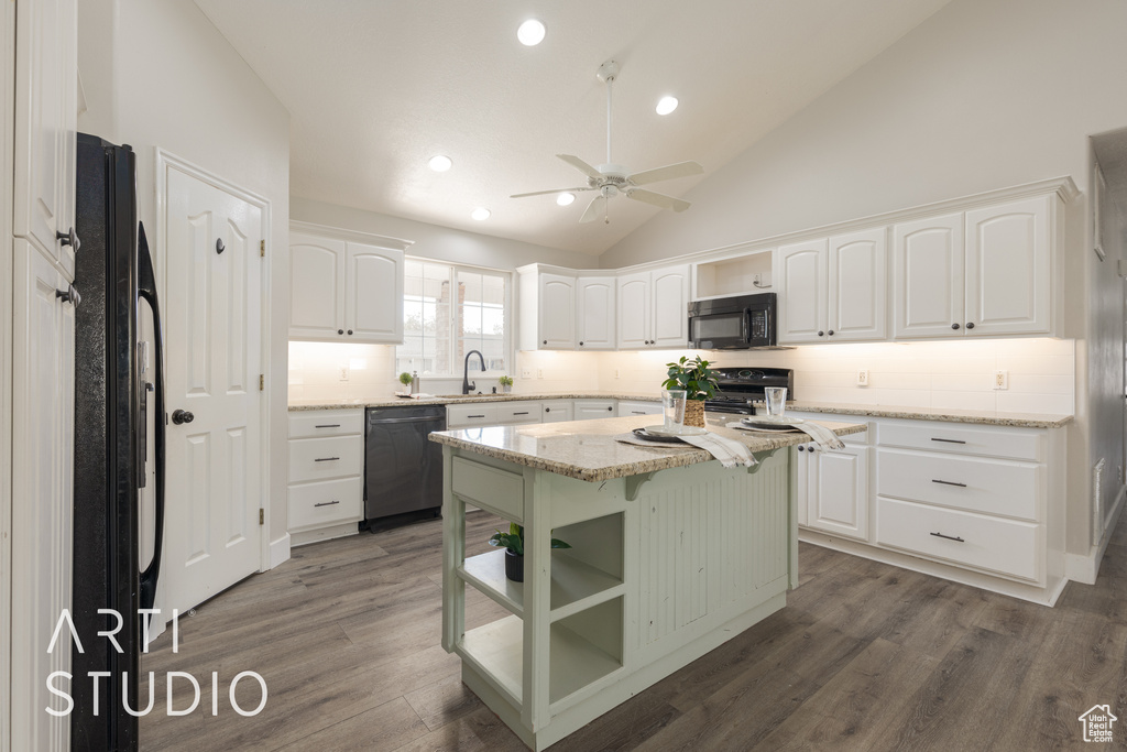 Kitchen with black appliances, a center island, dark wood-type flooring, and white cabinets