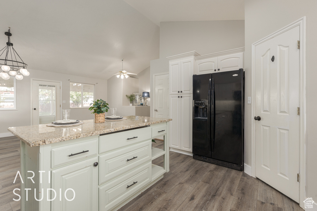 Kitchen featuring black refrigerator with ice dispenser, a center island, white cabinets, pendant lighting, and vaulted ceiling