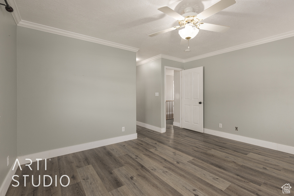 Spare room with ornamental molding, a textured ceiling, dark wood-type flooring, and ceiling fan