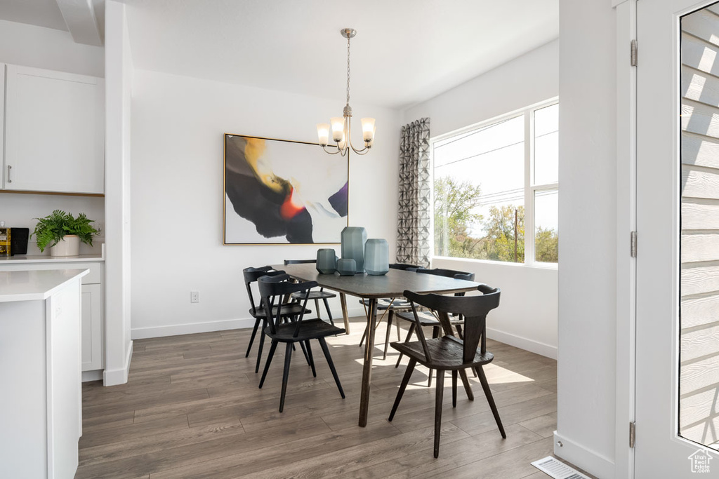 Dining area with an inviting chandelier and hardwood / wood-style flooring