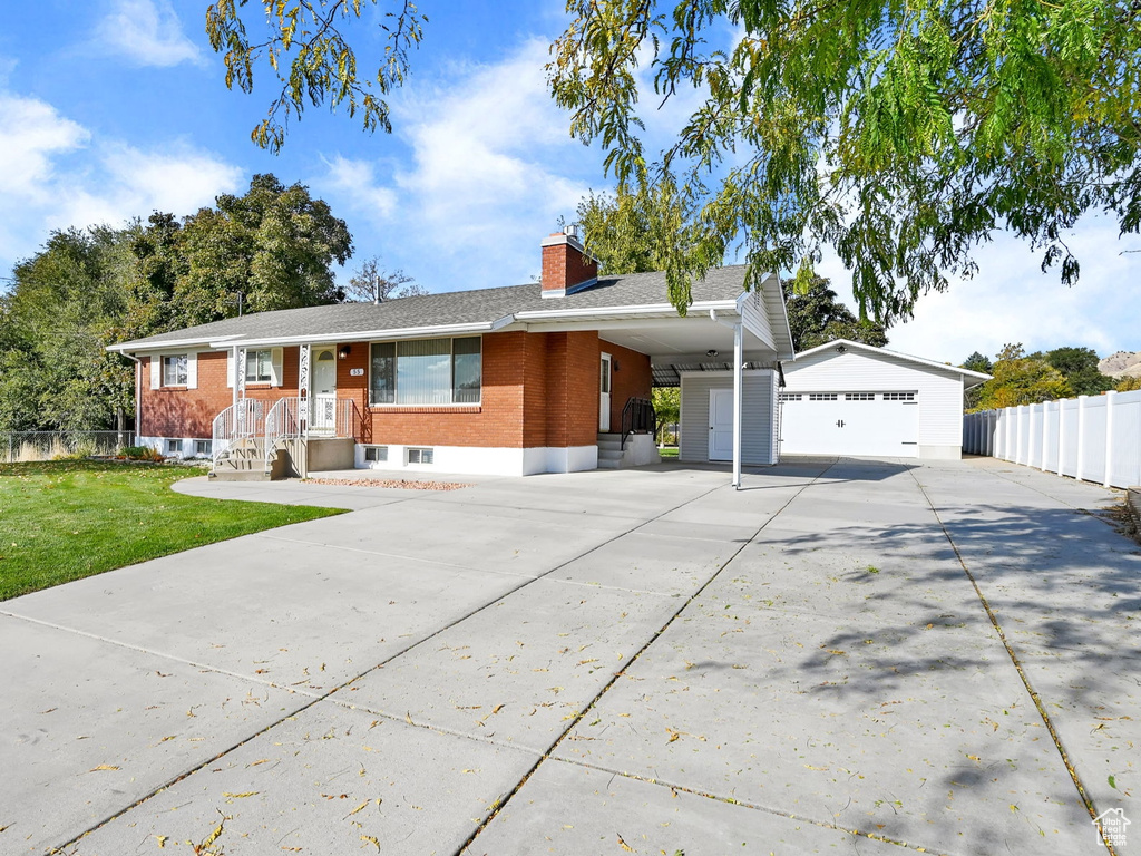 Ranch-style home featuring a front yard and a carport