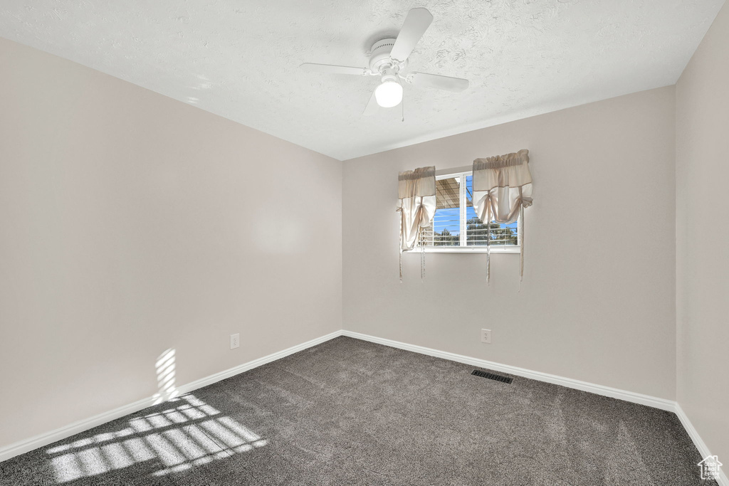 Unfurnished room featuring carpet flooring, a textured ceiling, and ceiling fan