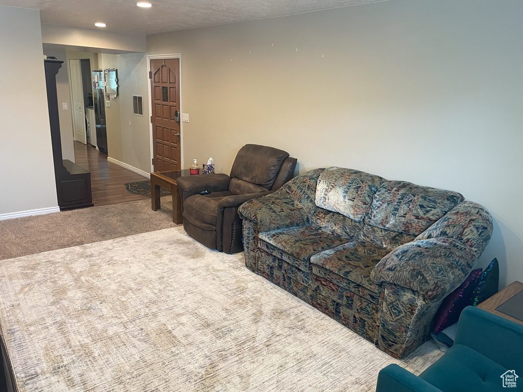 Living room with carpet floors, recessed lighting, and baseboards