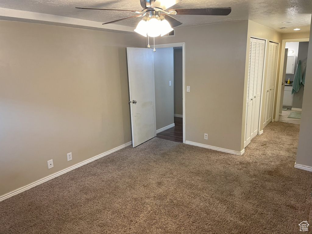 Unfurnished bedroom with carpet floors, a textured ceiling, baseboards, and ceiling fan