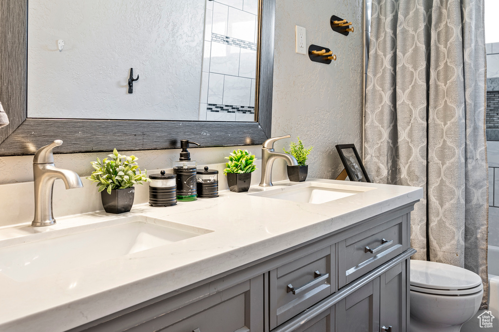 Full bathroom featuring toilet, shower / bath combo, and vanity