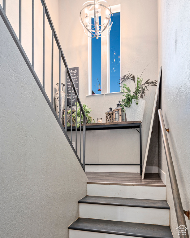 Stairs featuring an inviting chandelier