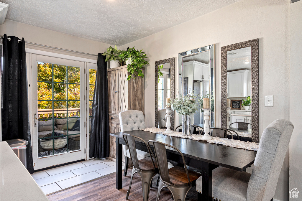 Dining space with a textured ceiling and hardwood / wood-style flooring