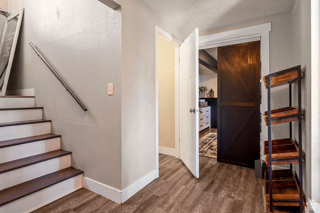 Staircase featuring wood-type flooring and a textured ceiling