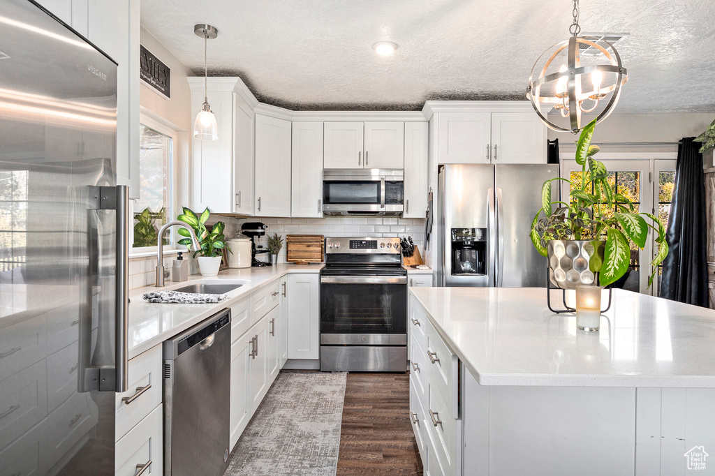 Kitchen featuring white cabinets, plenty of natural light, sink, and appliances with stainless steel finishes