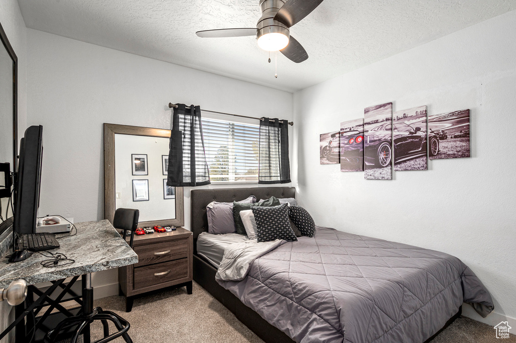 Bedroom featuring ceiling fan, a textured ceiling, and light carpet