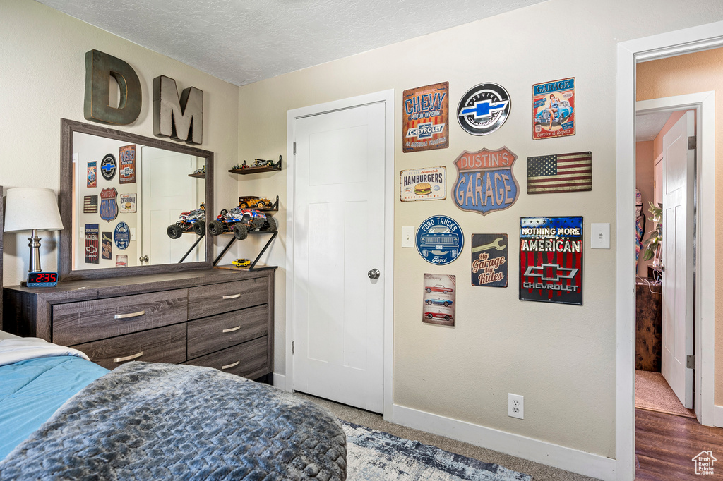 Bedroom with dark wood-type flooring and a textured ceiling