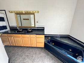 Bathroom featuring vanity and a tub to relax in