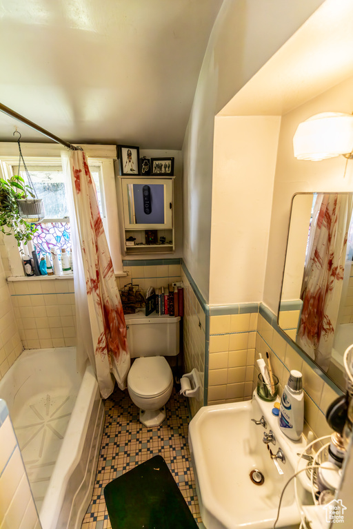 Bathroom featuring tile walls and toilet