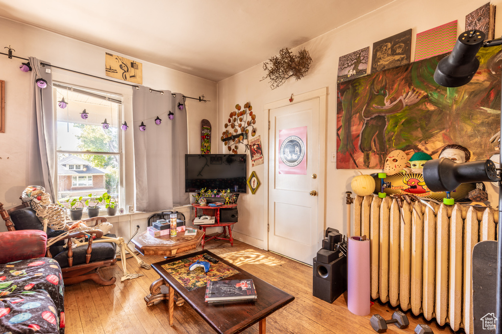 Living room with radiator heating unit and wood-type flooring