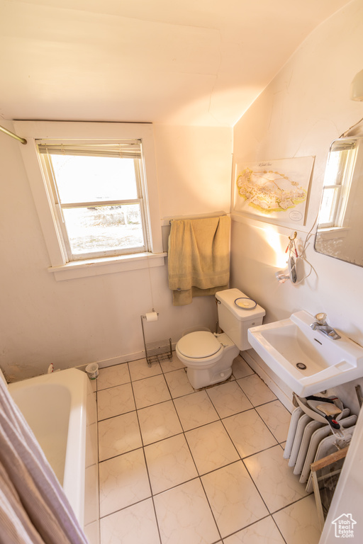 Bathroom with toilet, sink, and tile patterned floors