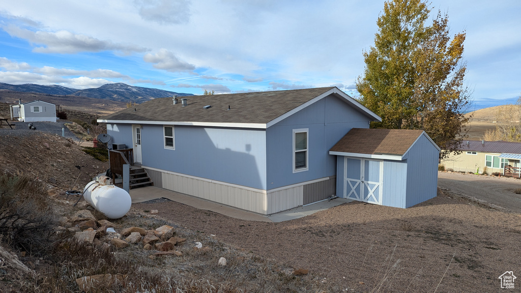 Rear view of house featuring a shed and a mountain view