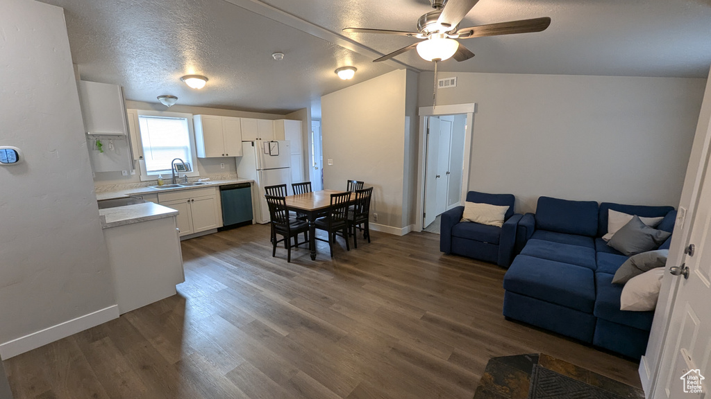 Living room featuring dark hardwood / wood-style flooring, sink, and lofted ceiling