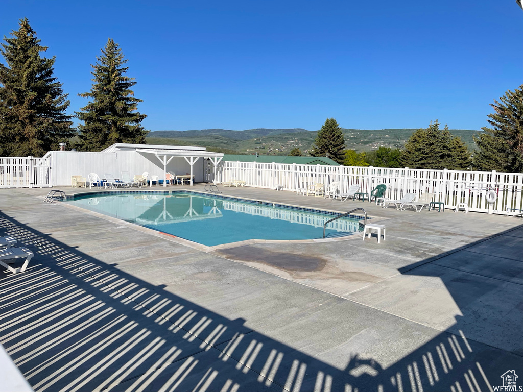 View of swimming pool with a mountain view and a patio area