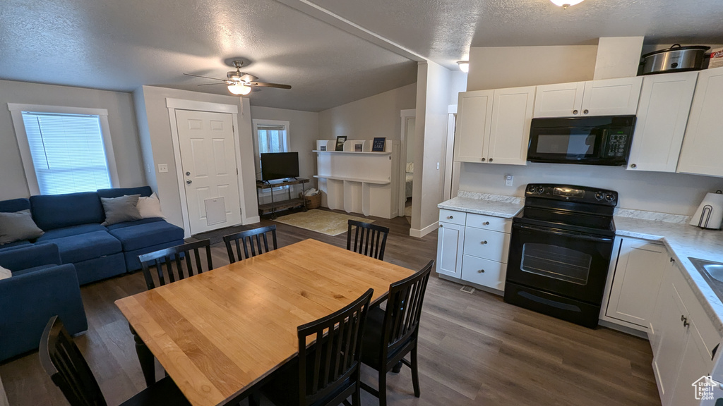 Dining area with lofted ceiling, a healthy amount of sunlight, ceiling fan, and dark hardwood / wood-style floors