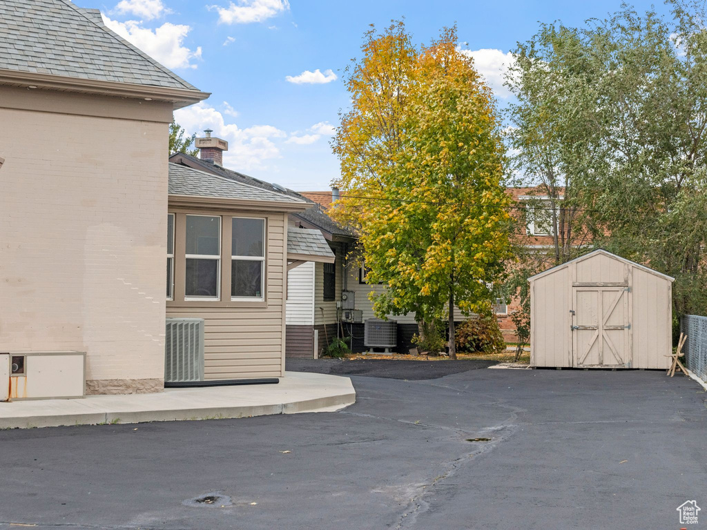 View of side of home featuring a shed, central AC, and a patio area