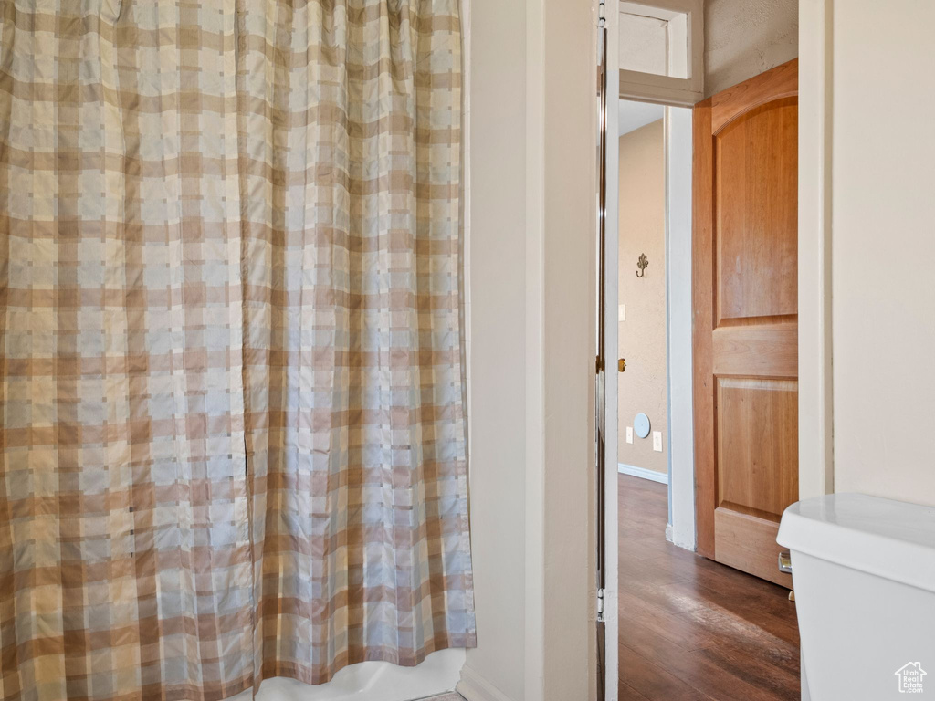 Bathroom featuring wood-type flooring and shower / tub combo with curtain