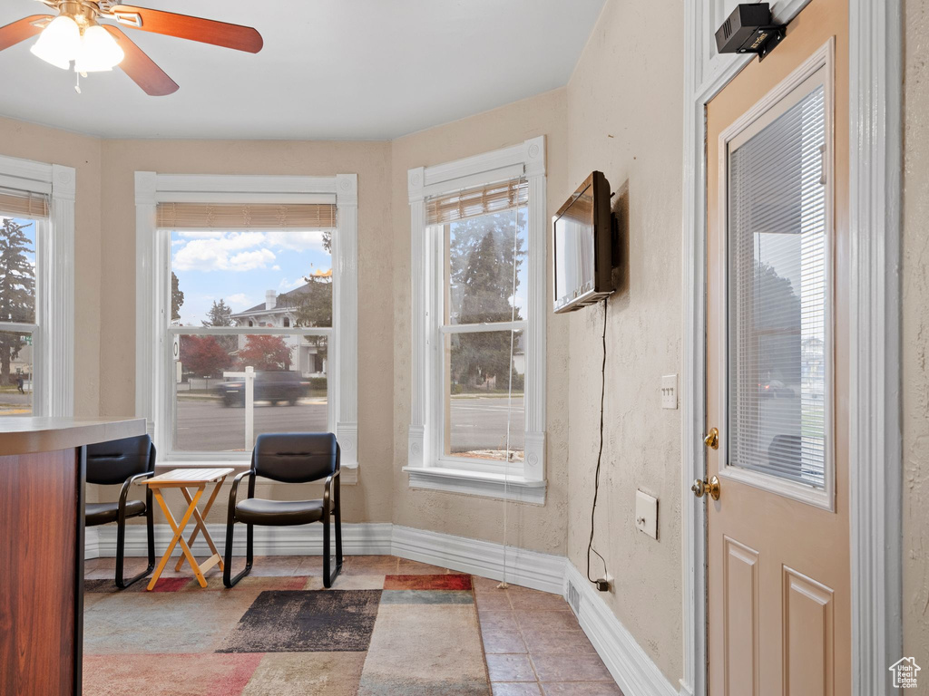 Entryway with ceiling fan and light tile patterned flooring