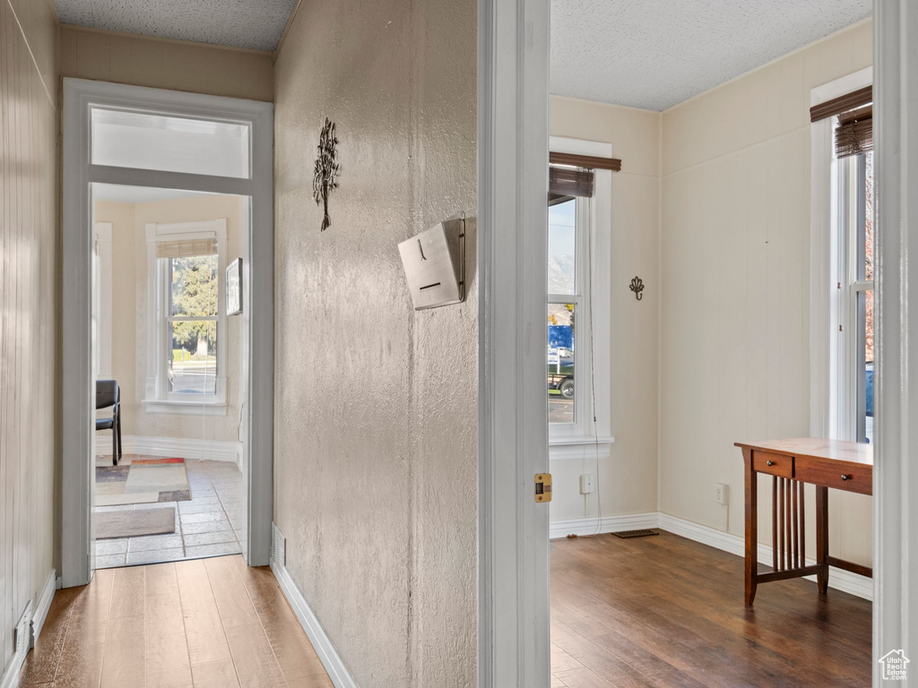 Hallway with dark hardwood / wood-style flooring and a textured ceiling