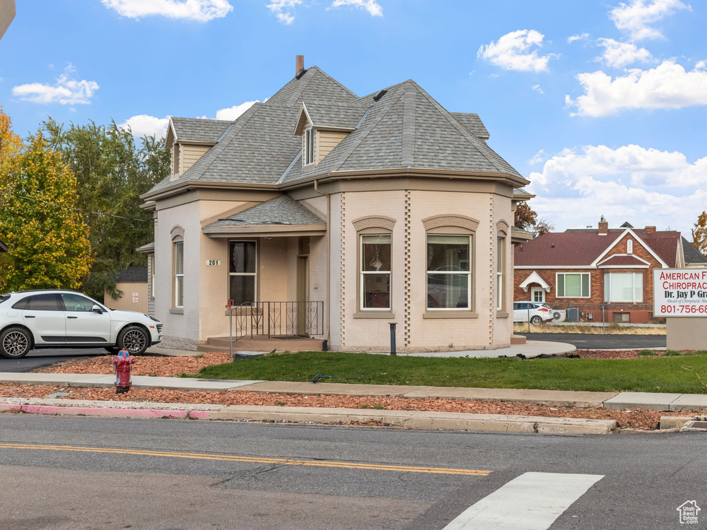 View of front of home with a front yard and covered porch