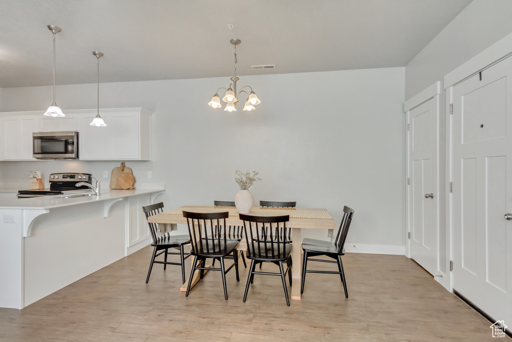 Dining room featuring a notable chandelier and light hardwood / wood-style floors