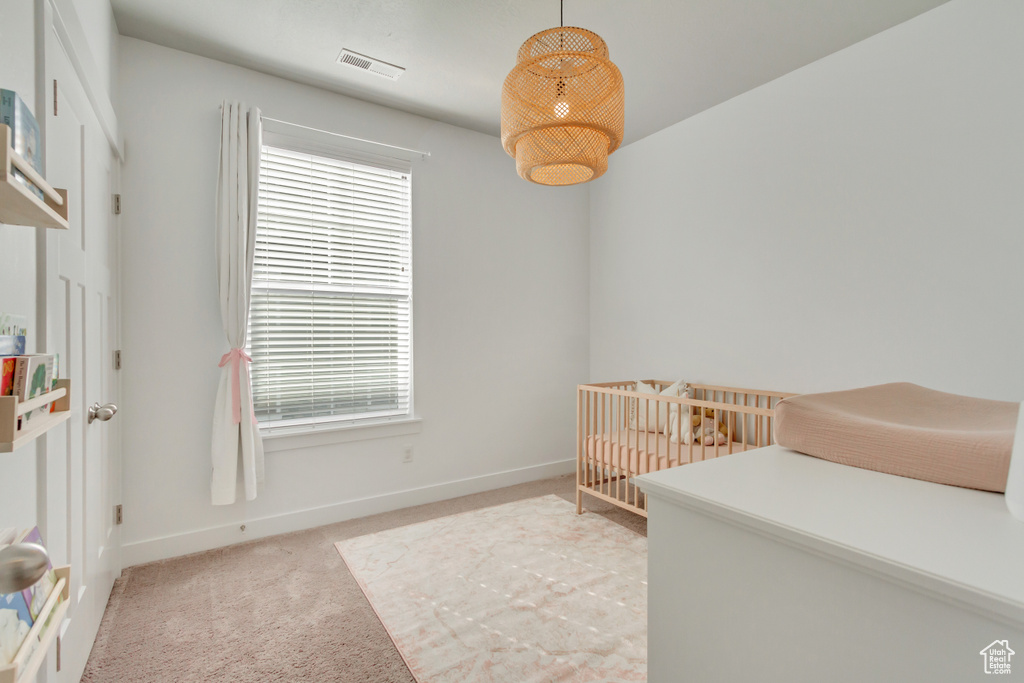 Carpeted bedroom featuring a nursery area