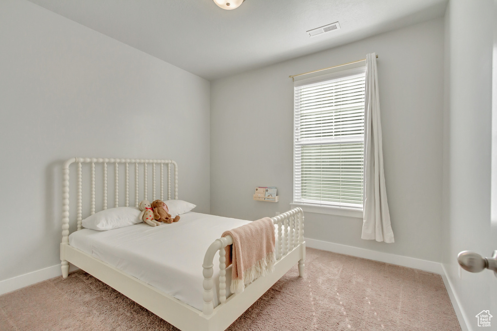 Carpeted bedroom featuring multiple windows