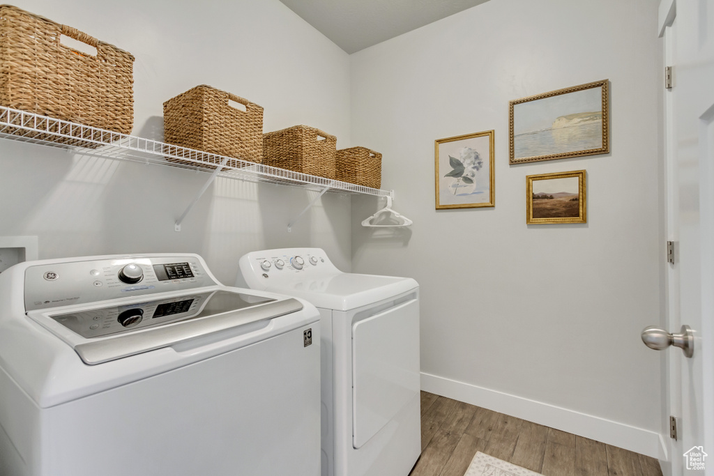 Laundry area featuring washer and clothes dryer and light wood-type flooring