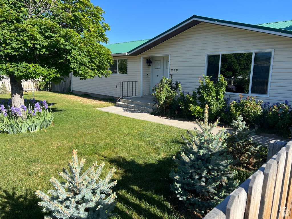 Single story home featuring metal roof and a front yard