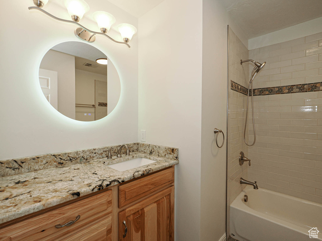 Bathroom with vanity and tiled shower / bath combo