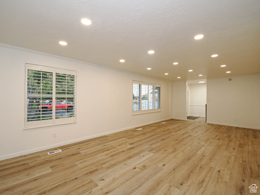 Unfurnished room with light hardwood / wood-style floors and crown molding