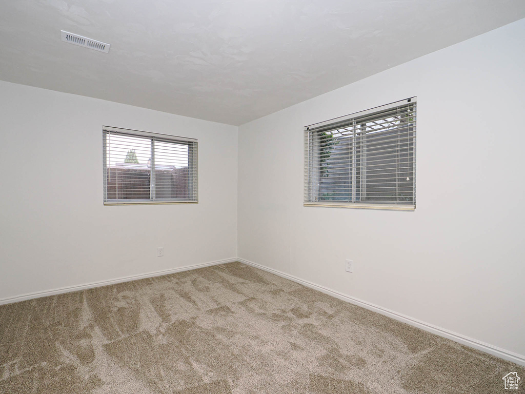 Unfurnished room featuring light carpet