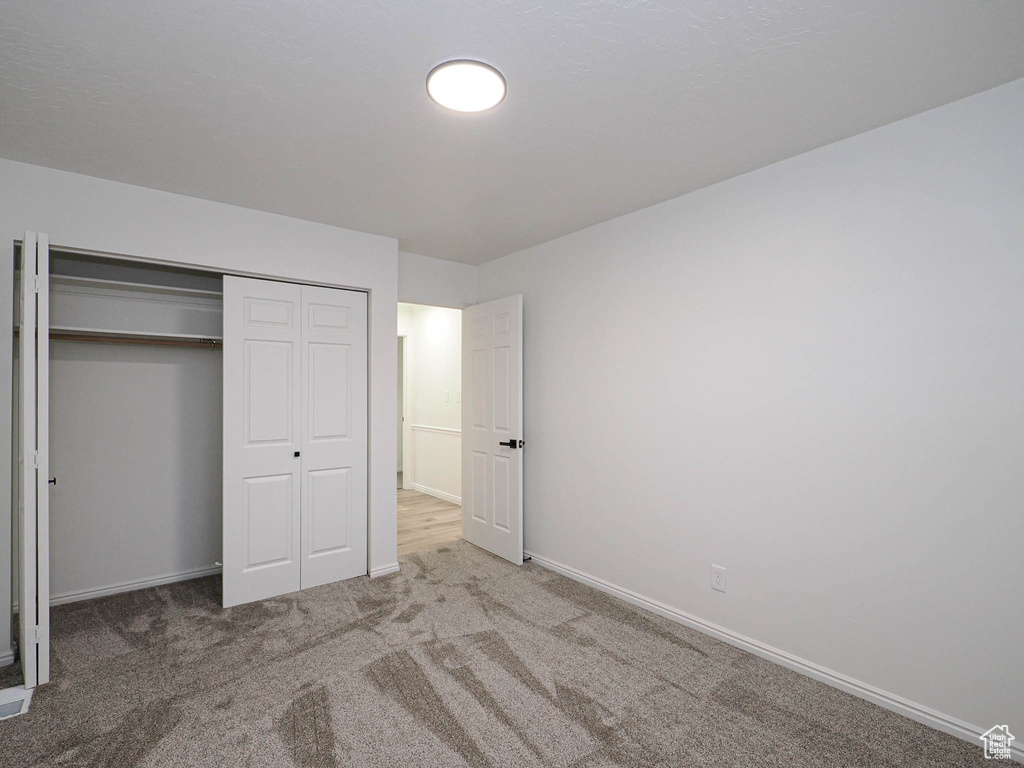 Unfurnished bedroom featuring carpet flooring and a closet