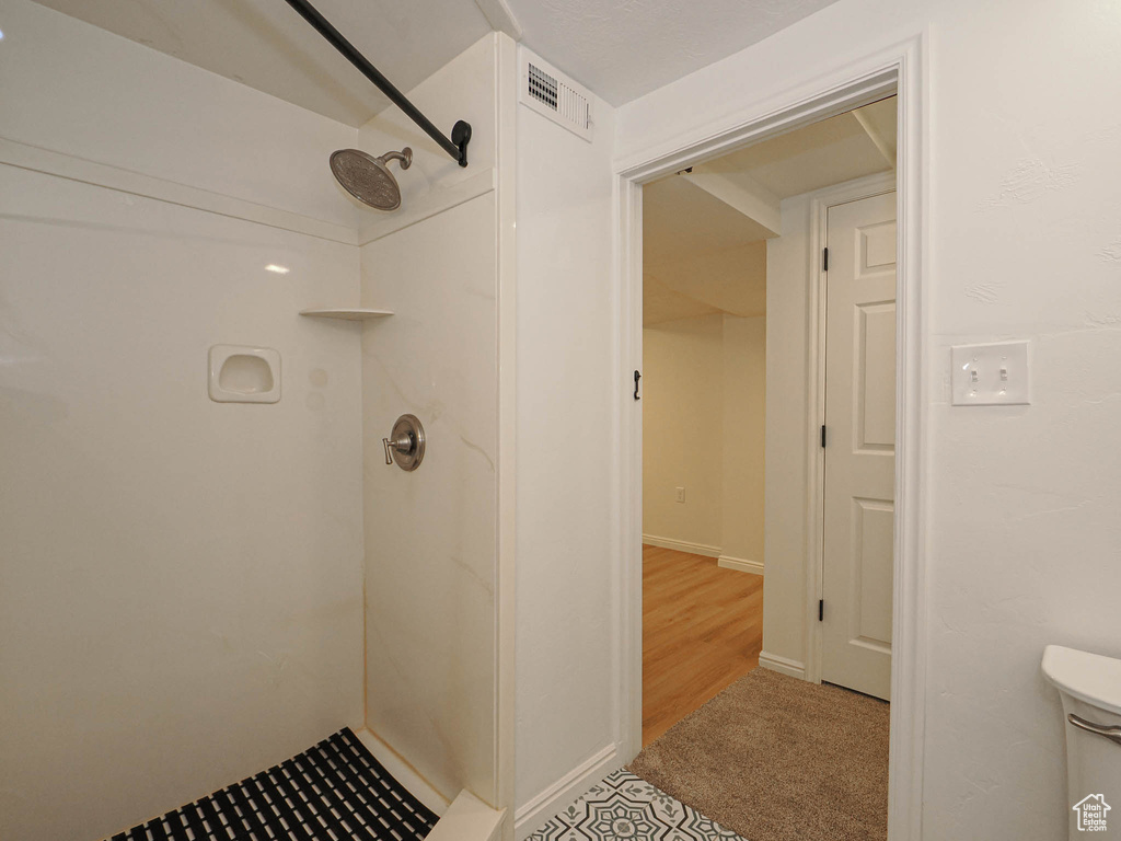 Bathroom with walk in shower and hardwood / wood-style floors