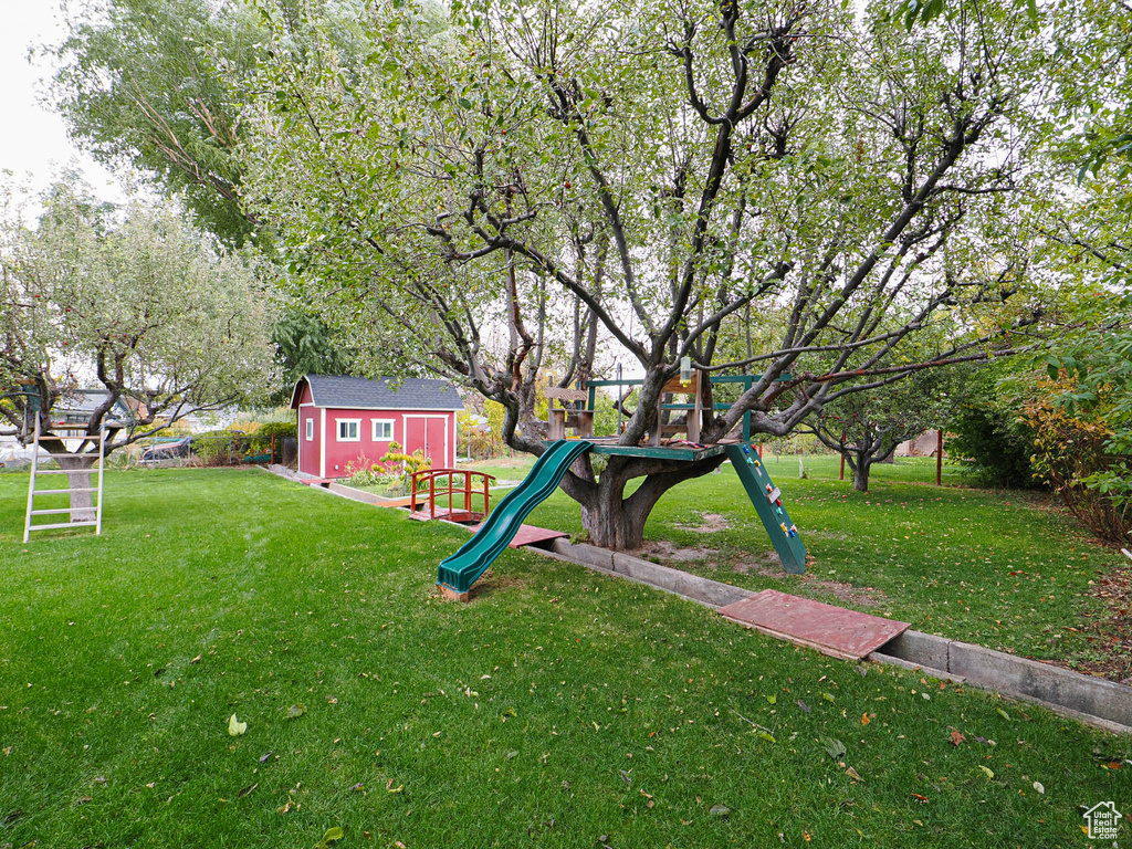 View of yard featuring an outbuilding and a playground