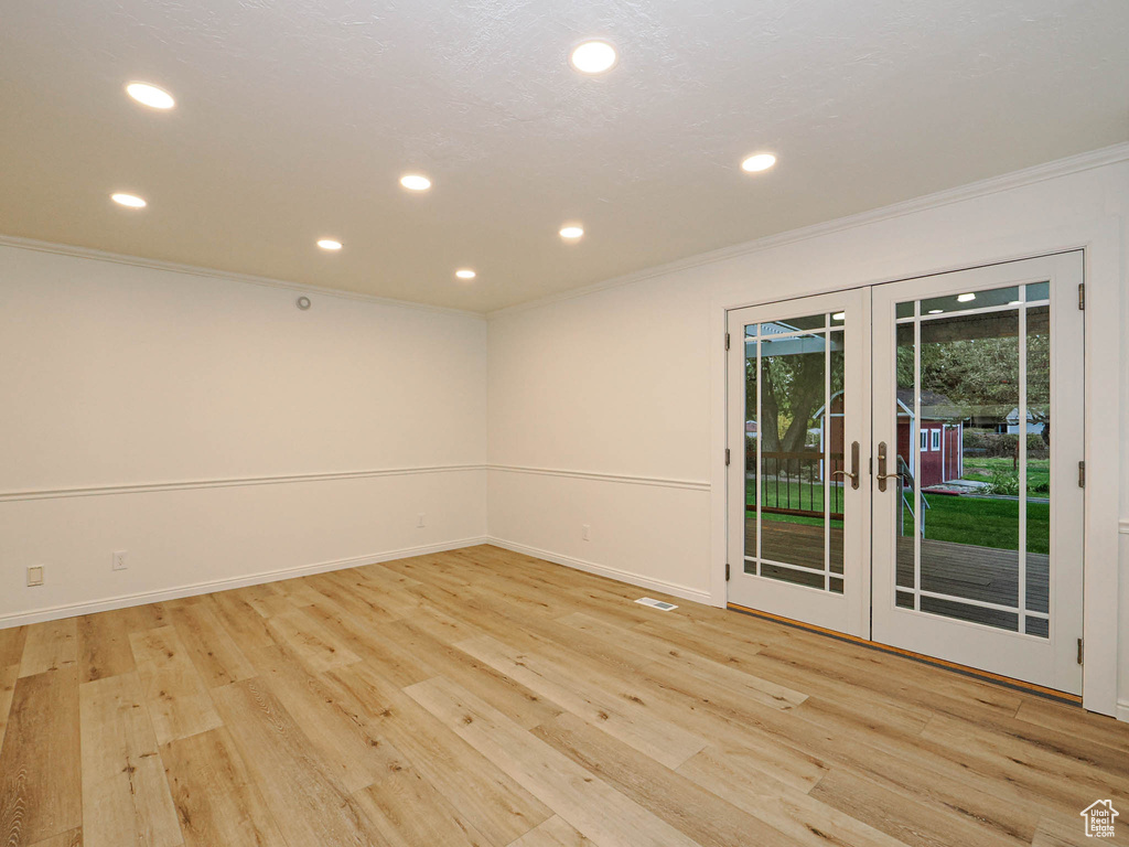 Empty room featuring light hardwood / wood-style floors, french doors, and ornamental molding